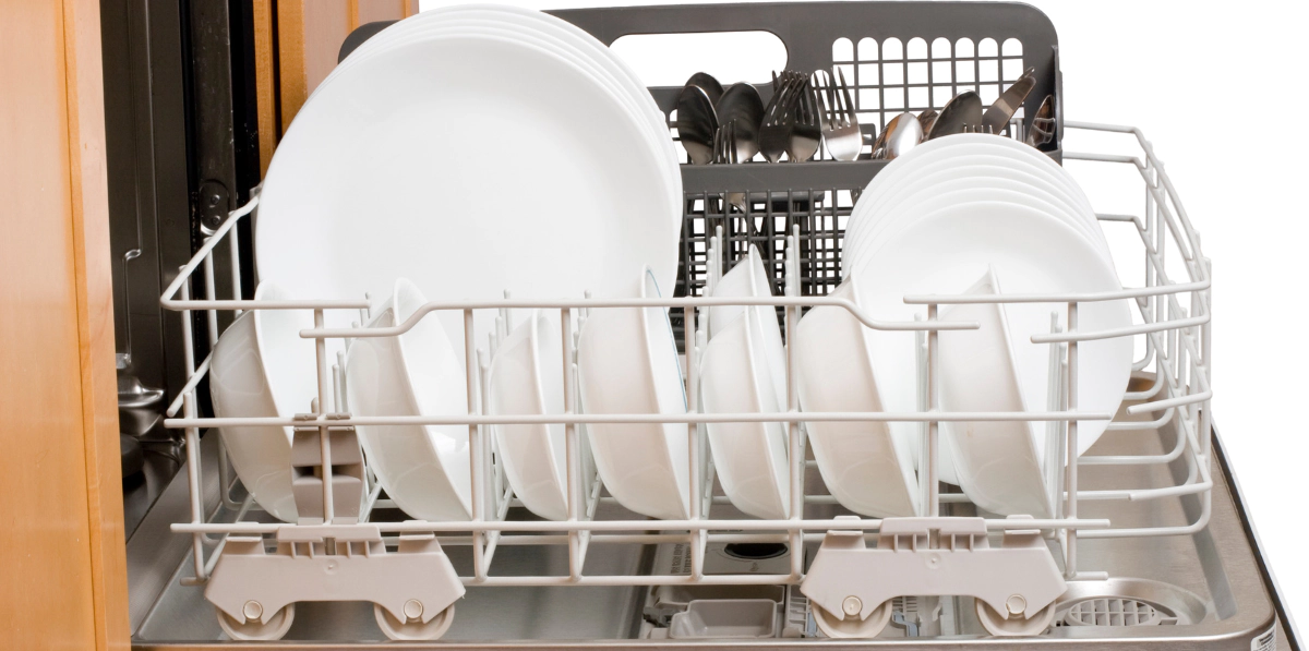 an open dishwasher with utensils on the racks
